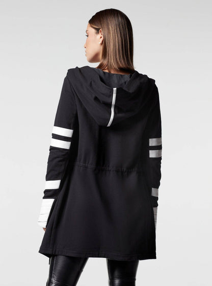 Black hooded jacket with white stripes on sleeves worn by a person on a light gray background