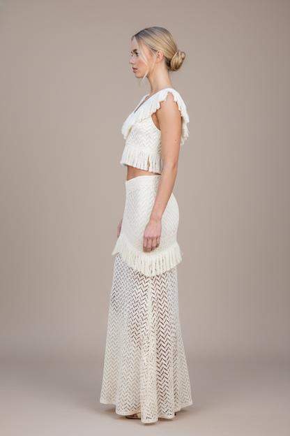 Woman wearing a white lace outfit on a plain background