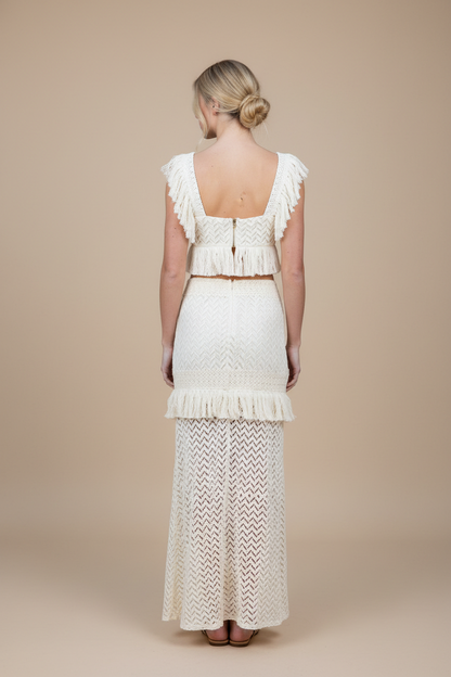 Woman wearing a white lace dress with a beige background