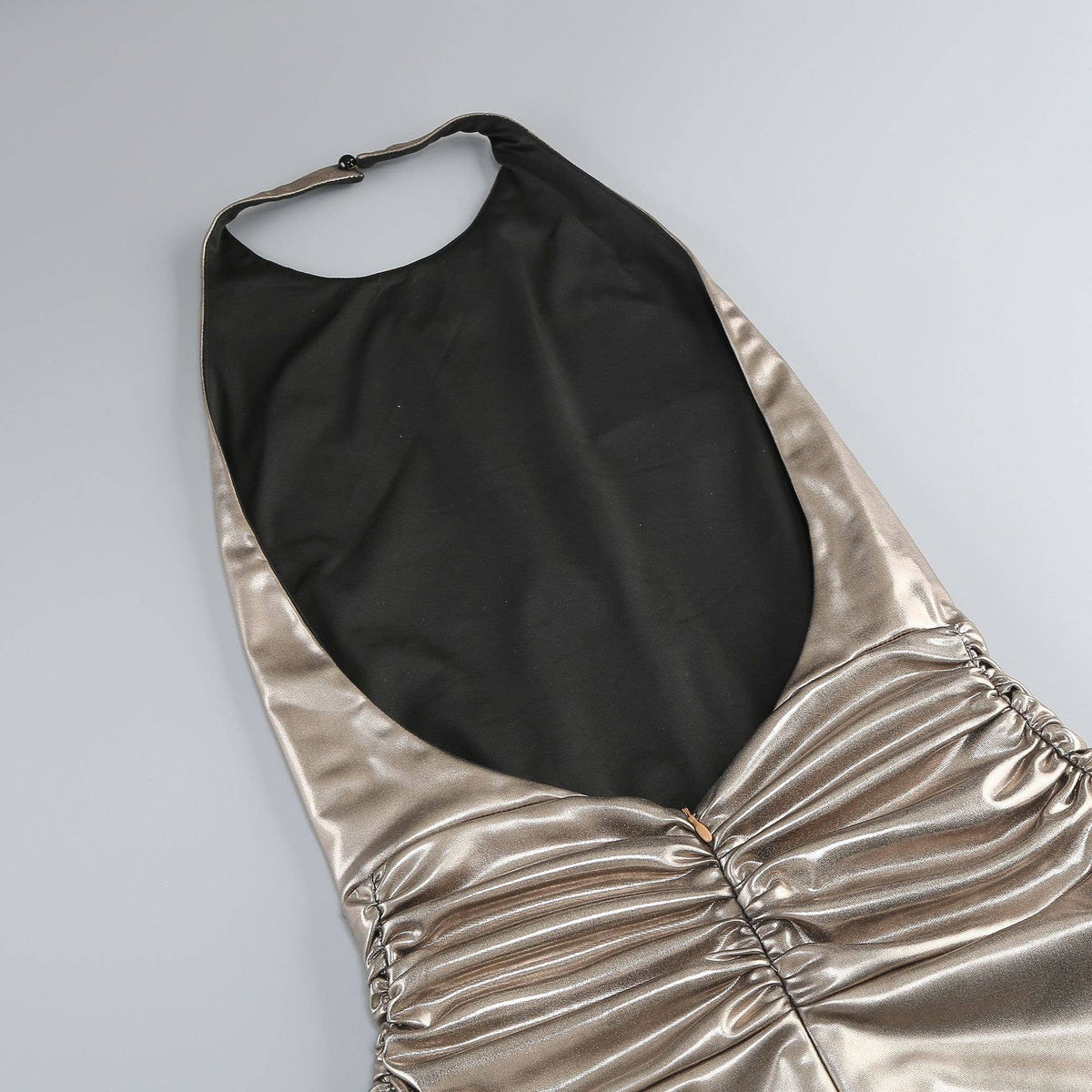Gold and black halter top on a light gray background