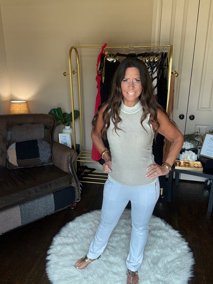 Woman sitting on a fluffy white rug in a room with a mirror and furniture.