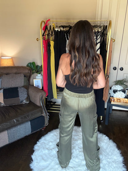 Person standing in front of a mirror with a suitcase open on the floor, possibly packing or unpacking.