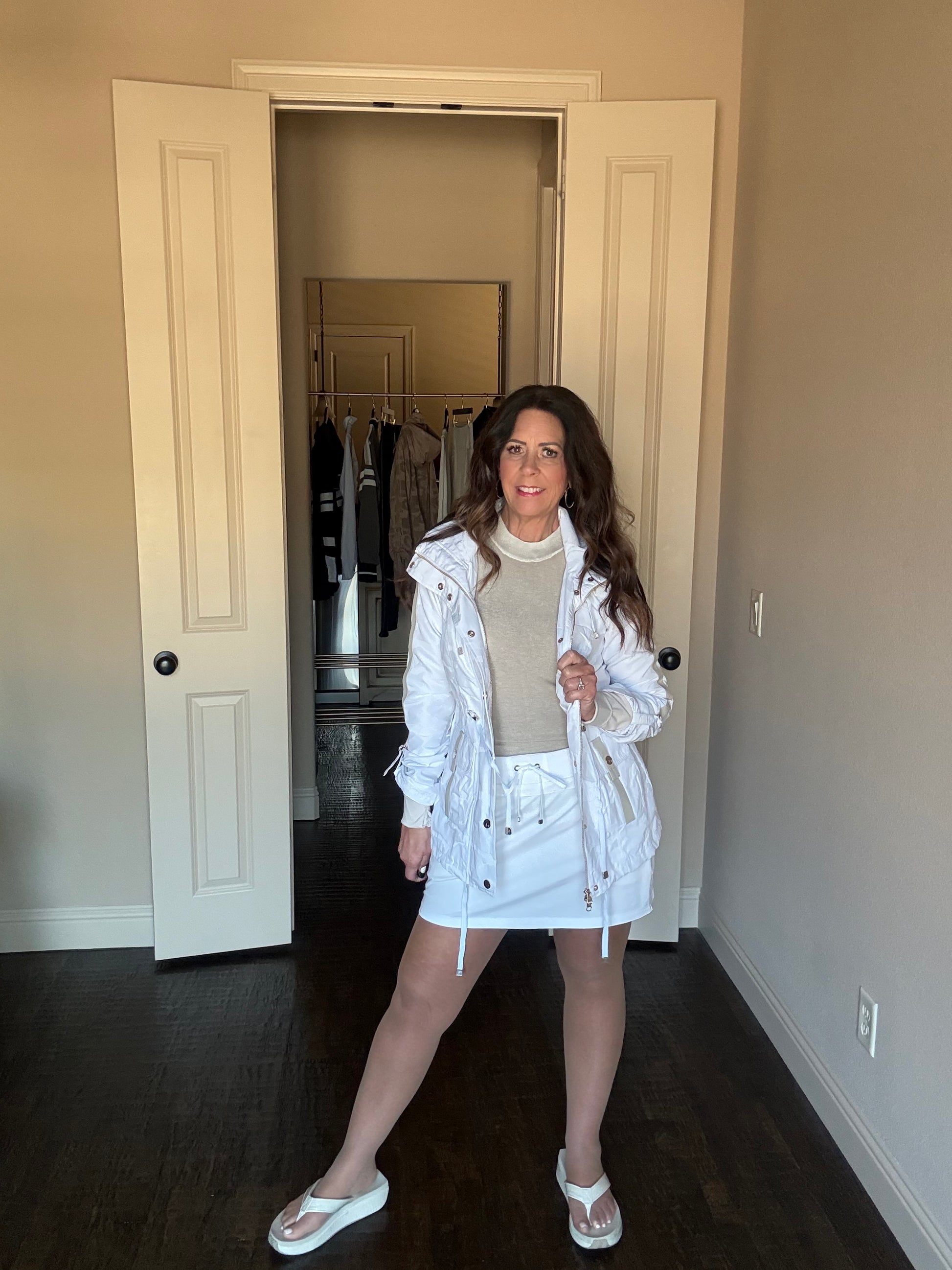 Woman in a white dress standing in front of a door
