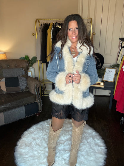 Amy black lace-trim shorts styled with a denim jacket with cream faux fur trim and tall beige boots.
