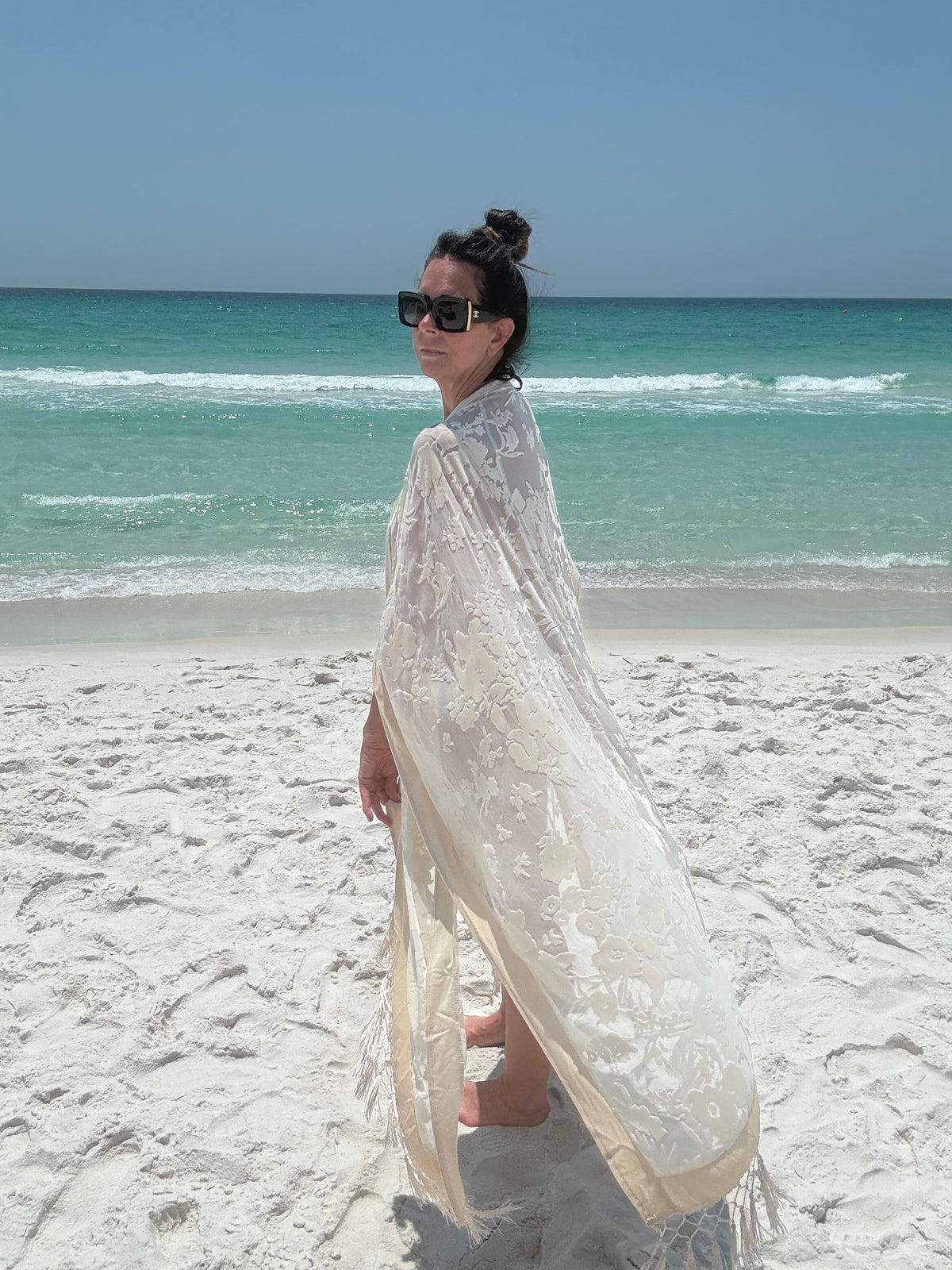 ivory kimono worn by womAN ON BEACH WIOTH OCEAN BACKGROUND