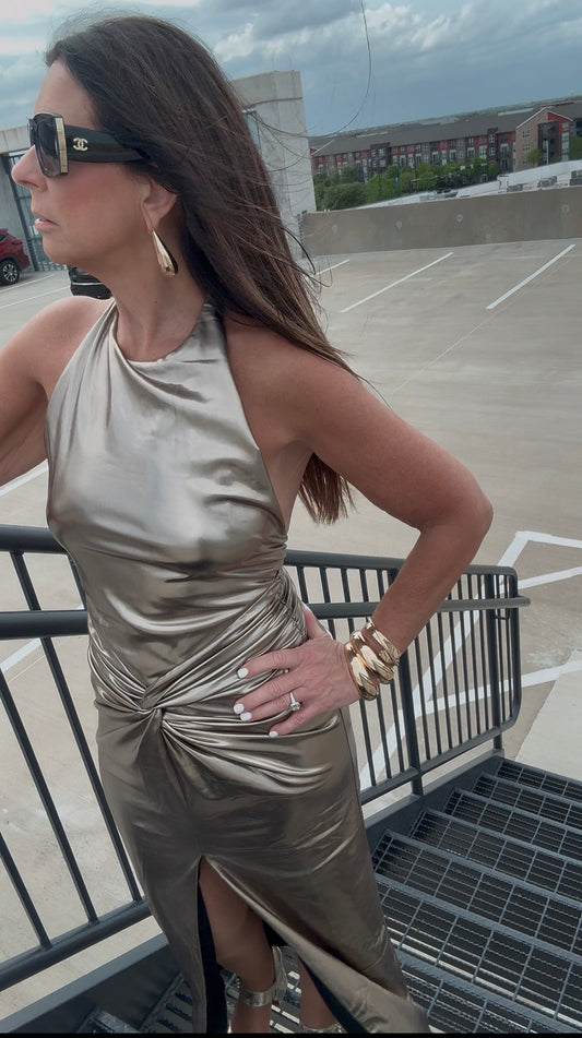 Woman in a metallic dress standing on a rooftop with a cityscape background