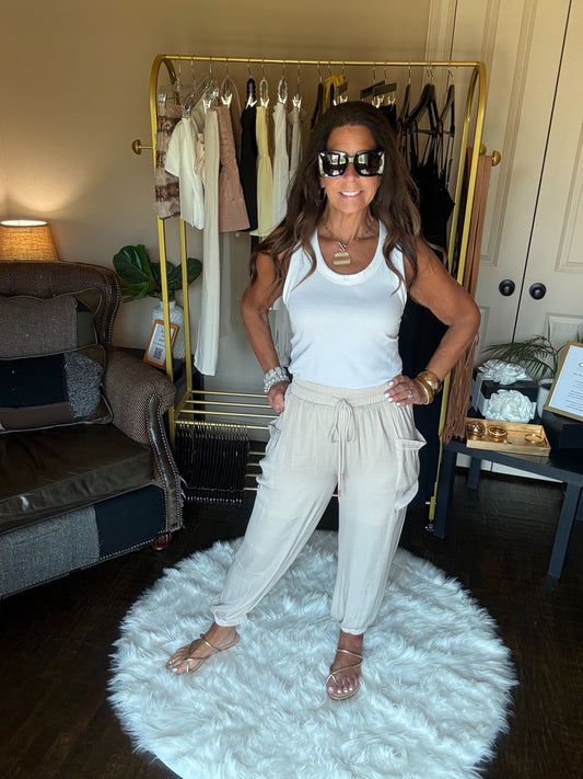 Woman posing in a room with a rack of clothes and a couch.