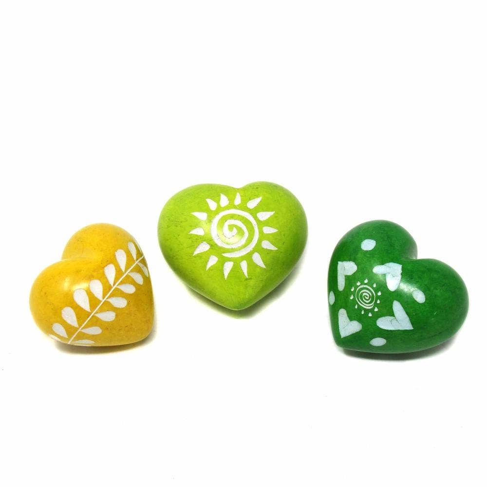 Three heart-shaped stones with white designs on a white background