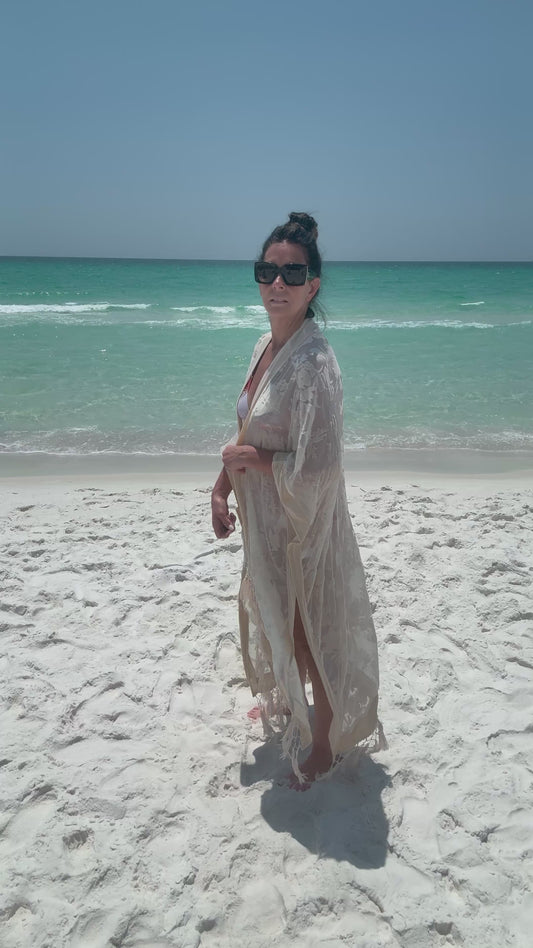 ivory kimono worn by womAN ON BEACH WIOTH OCEAN BACKGROUND