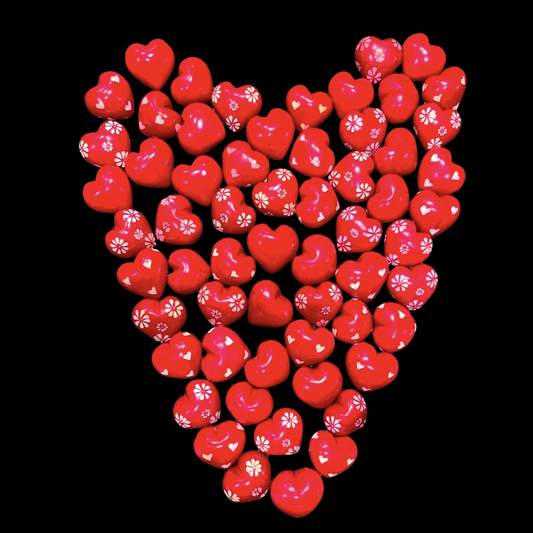 Red heart-shaped candies arranged in a pattern on a black background